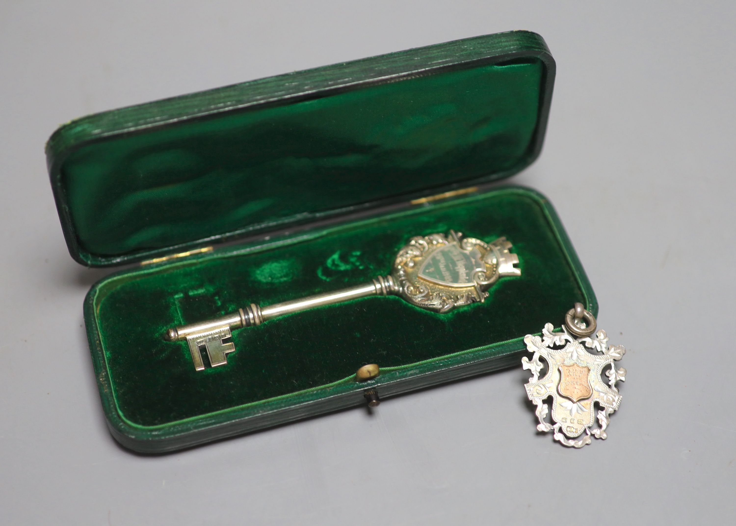 A cased Edwardian parcel gilt silver presentation key, Birmingham, 1908, 10.2cm and a late Victorian silver medallion.